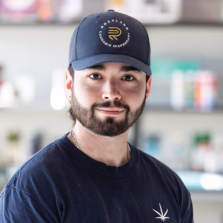 Eric, known as the Fixer, wearing a branded navy cap indoors